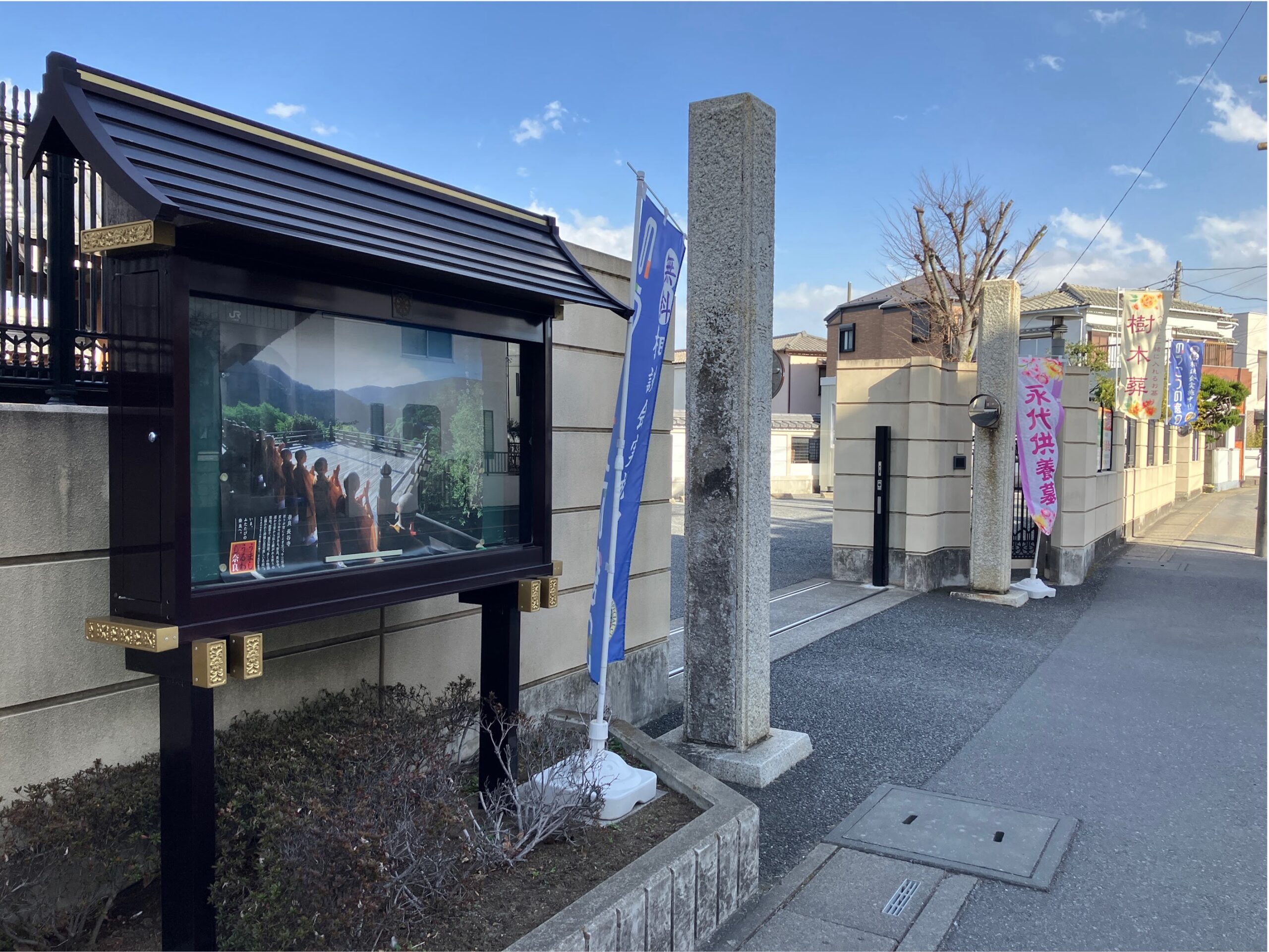 歩道沿いに「緑樹の郷」がございます。 掲示板とのぼり旗が目印です。 自家用車の場合にもこちらからお入りください。
